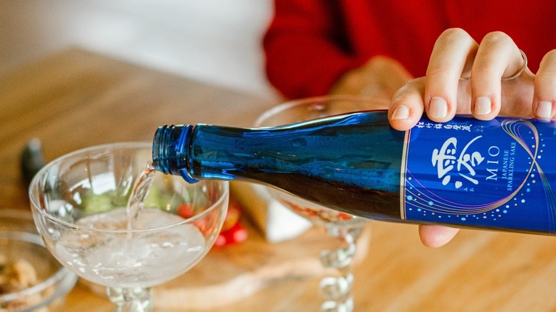 a person pouring sparkling sake into a glass