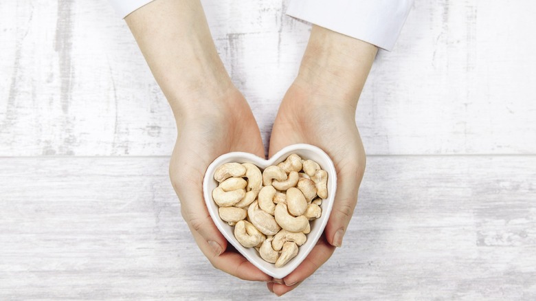 Hands holding bowl of cashews