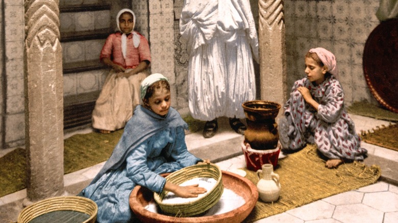 Algerian girls making couscous in 1900s