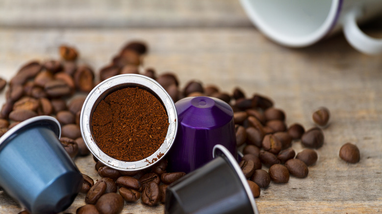 Coffee pods of various colors on pile of coffee beans