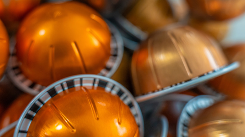 Close-up of pile of orange Nespresso pods