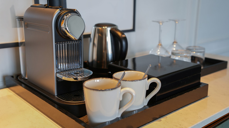 Nespresso machine next to two cups of coffee on counter