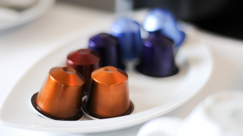 Nespresso capsules in varying colors on white plate