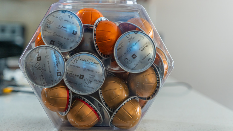 Clear container full of orange Nespresso pods