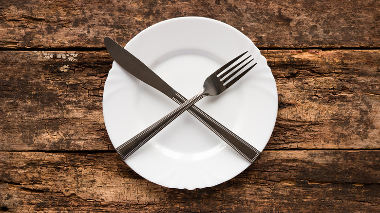 Knife and fork crossed on plate