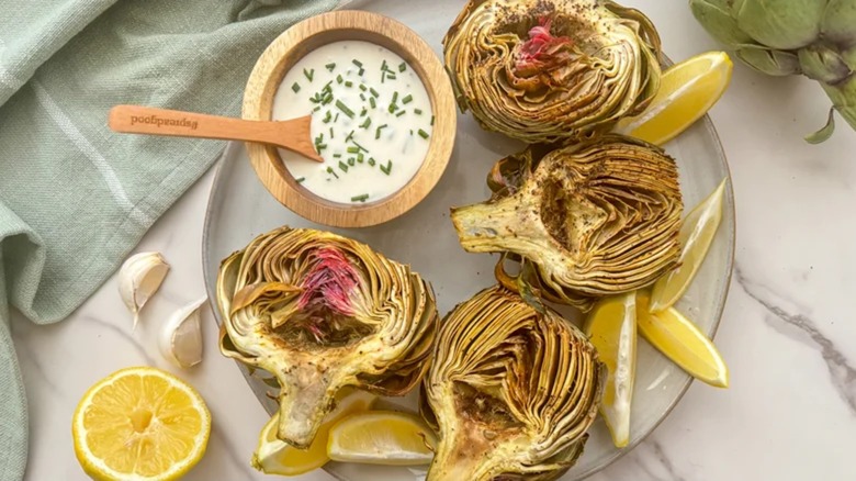 Sliced artichokes with dip on a plate