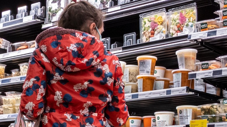Woman looking at Whole Foods soups 