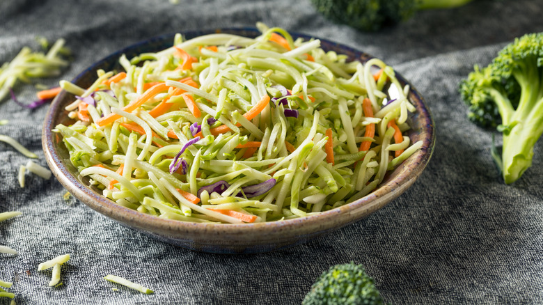 broccoli slaw in bowl with whole broccoli on side