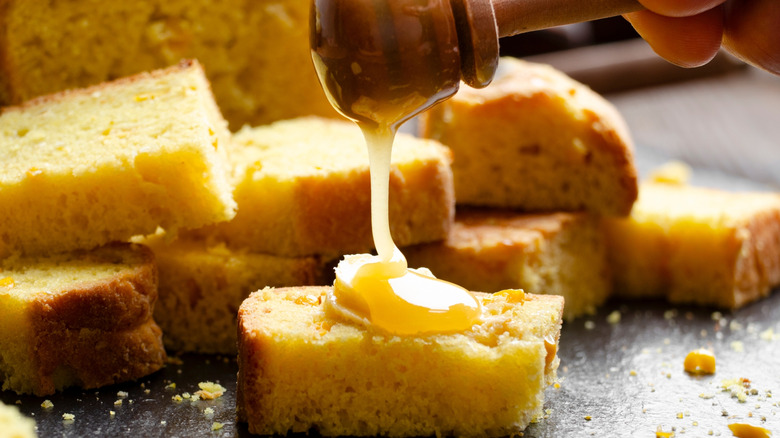 Cornbread with honey and butter drizzle on black surface