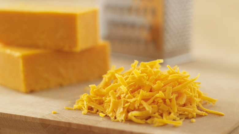 Shredded cheese in a pile on a block