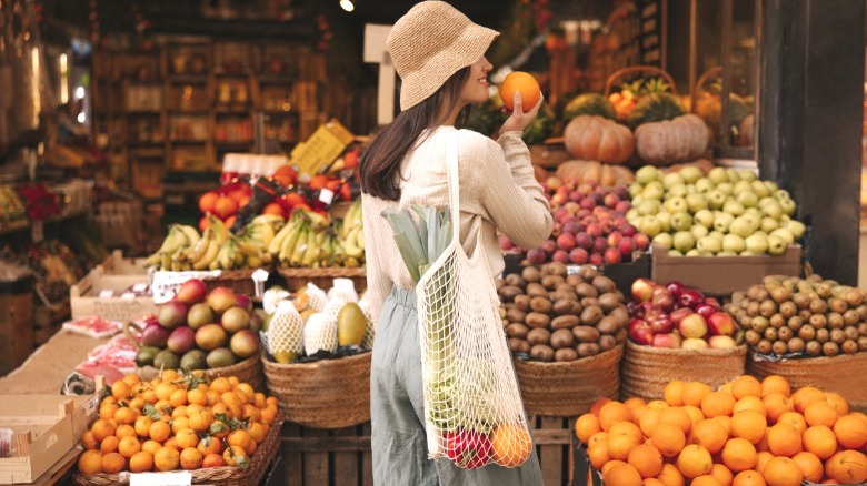 Woman picking fruit at market