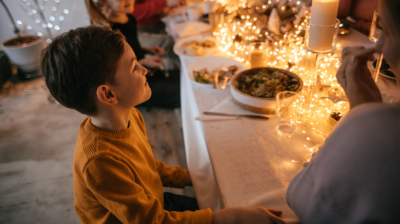 young boy at a holiday table with lights