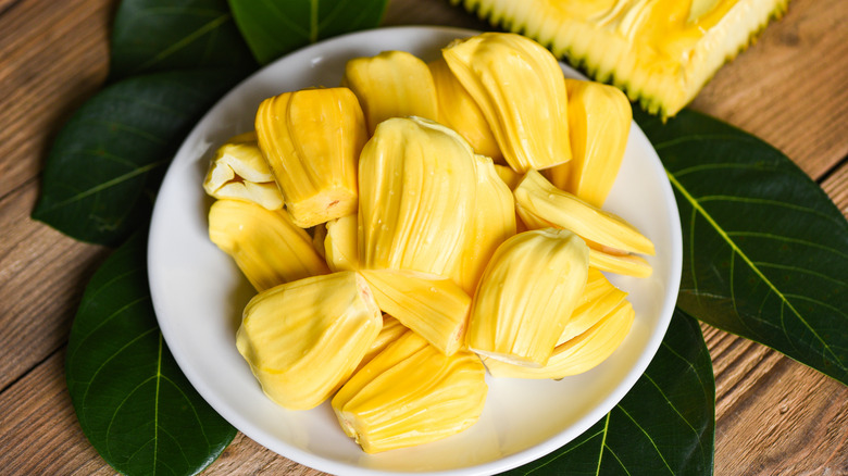 jackfruit on a white plate with a leaf and wooden background