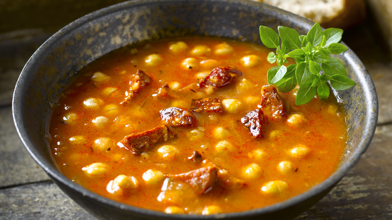 close up of tomato-based chick pea soup with sausage chunks