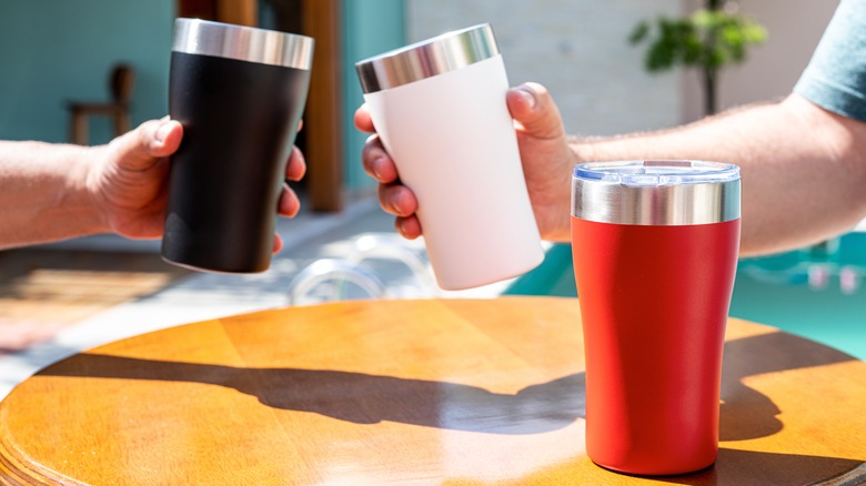 hands holding tumblers