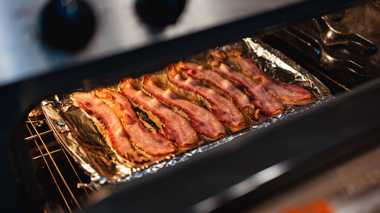 A tray of bacon cooking in an oven