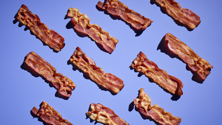 Crispy bacon strips on blue background