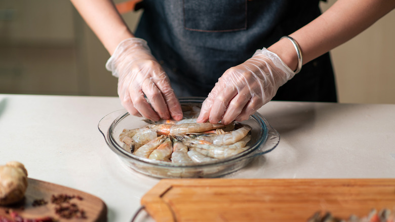 chef handling shrimp with gloves