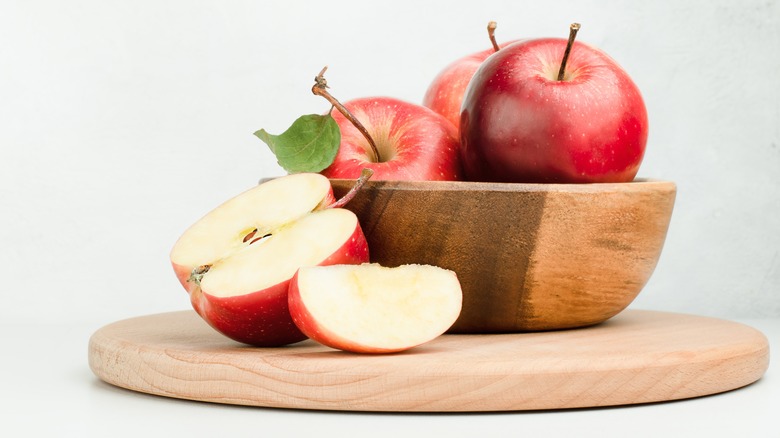 Red apples in wooden bowl