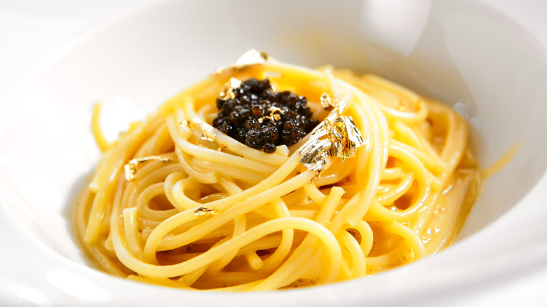 Spaghetti topped with caviar and golden leaves