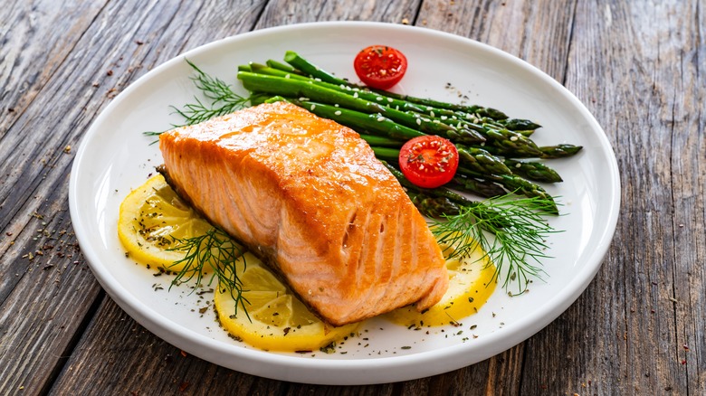 Plated salmon and asparagus on wooden table