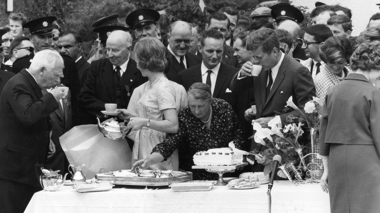 JFK and a group standing around a table of food