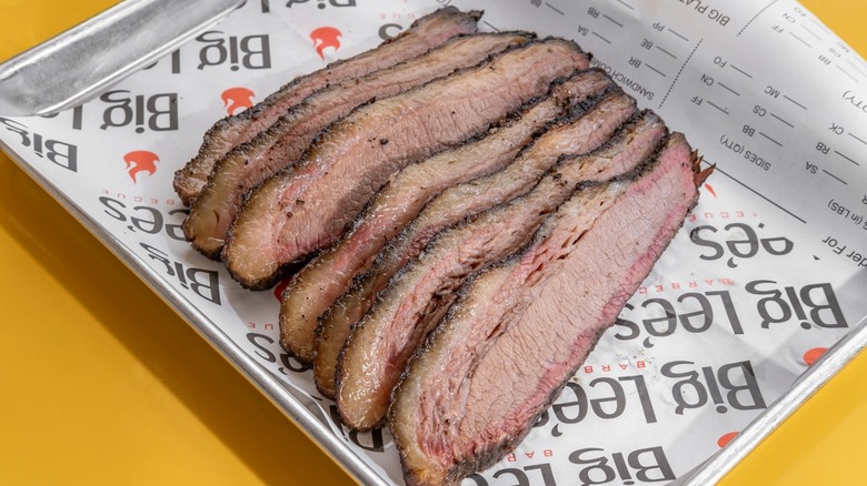 Slices of brisket on a tray with paper from Big Lee's