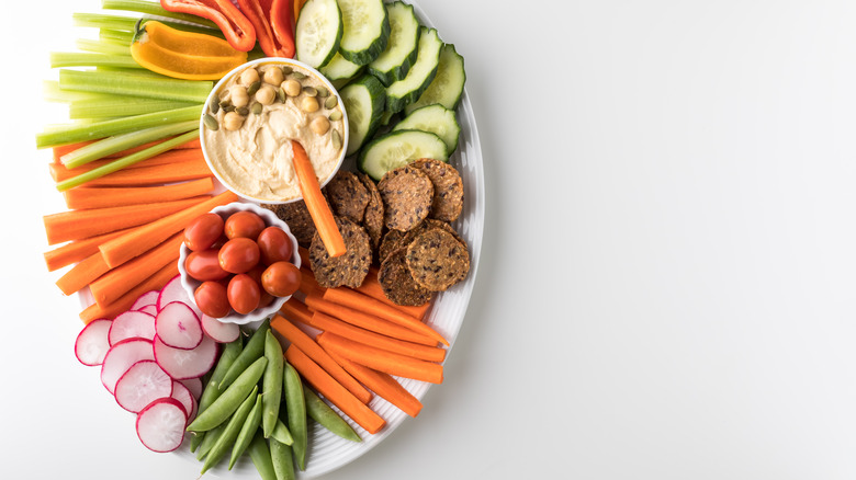 crudite platter with hummus on white background