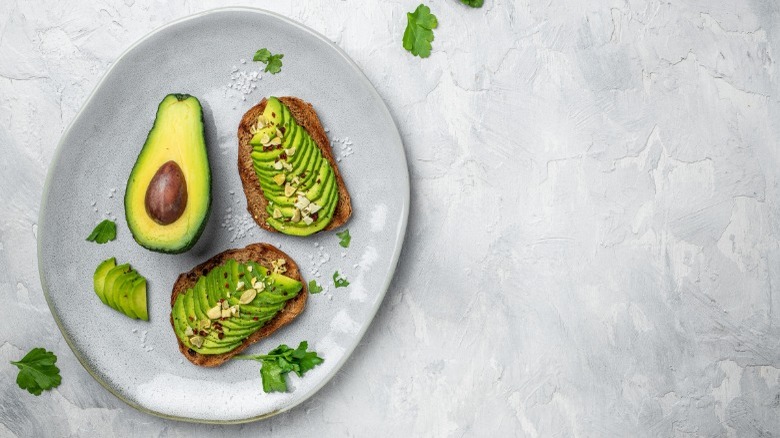 Halved avocado and avocado toast