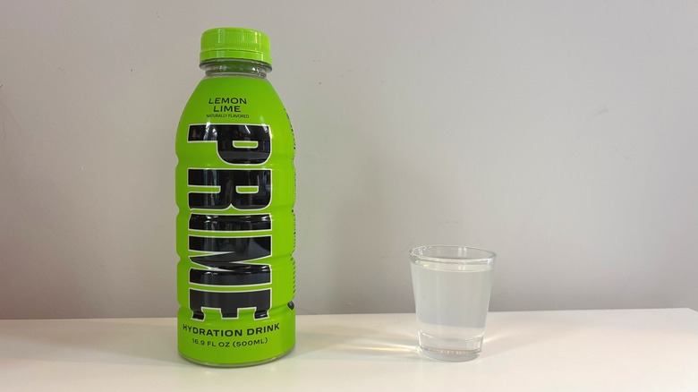 Prime Lemon Lime bottle next to shot glass with drink on white table