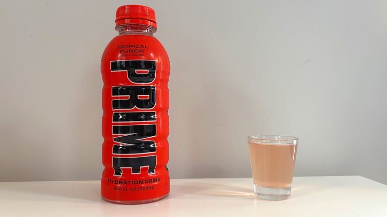 Prime Tropical Punch bottle next to shot glass with drink on white table