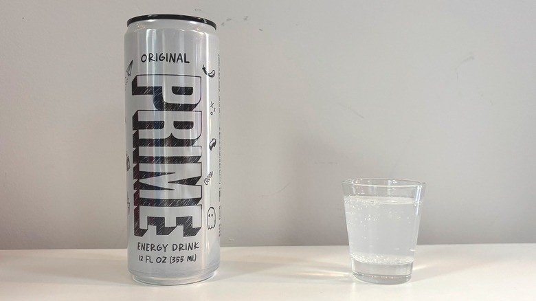 Prime Original can next to shot glass with drink on white table