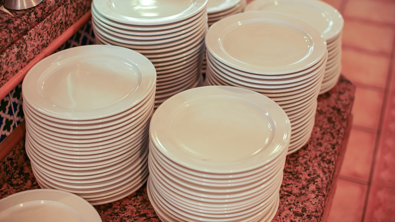 stacked white plates at buffet