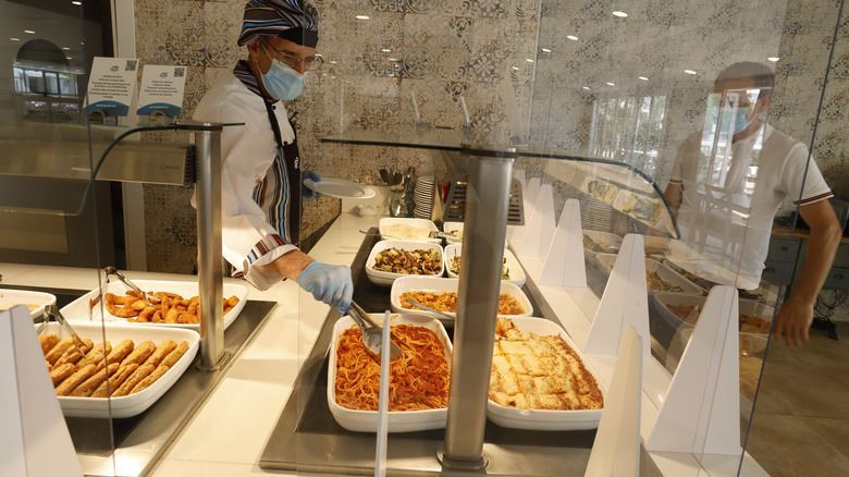 server wearing protective gear at buffet