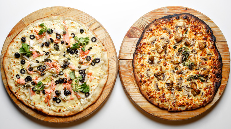 Two pizzas on cutting boards