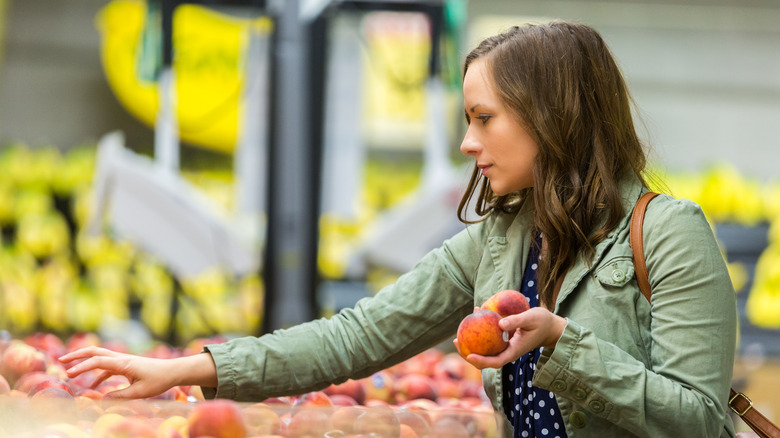 woman choosing a peach