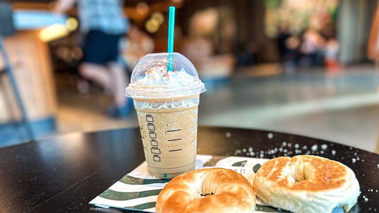 Starbucks drink and bagel on table