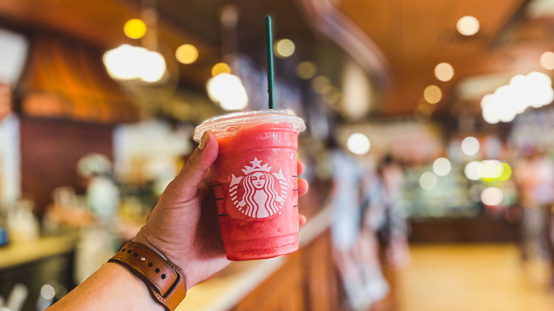 Person holding red Starbucks drink