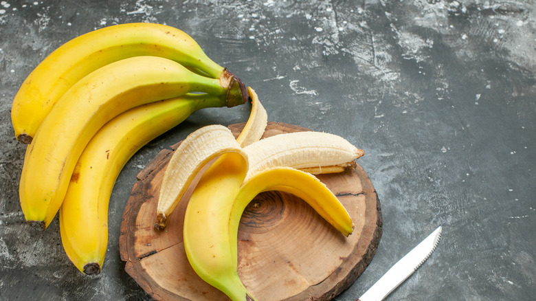 Bananas with knife on table