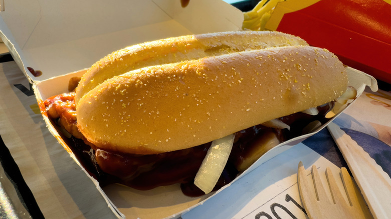 Open box with McDonald's McRib sandwich next to fries