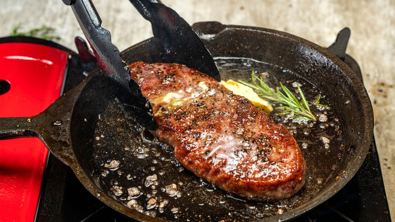 flipping steak with tongs