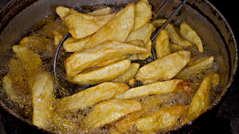 French fries cooking in cast-iron pan