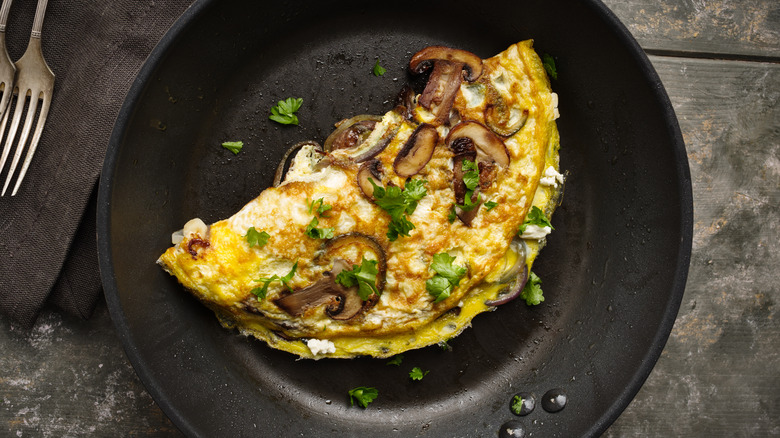 Folded mushroom omelet in pan