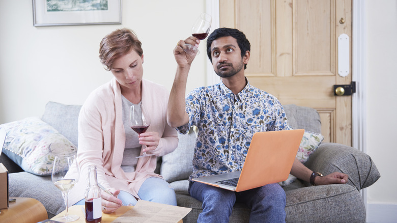 Two people tasting wine and taking notes together