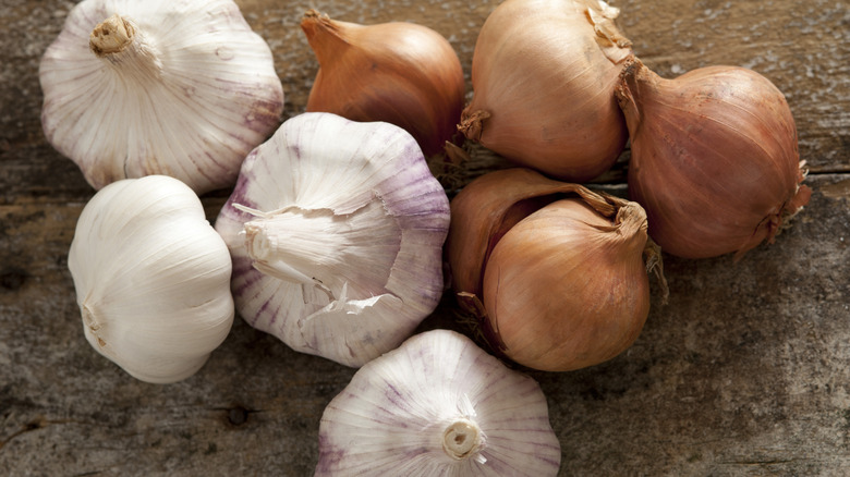 Fresh raw garlic and onions on wooden table