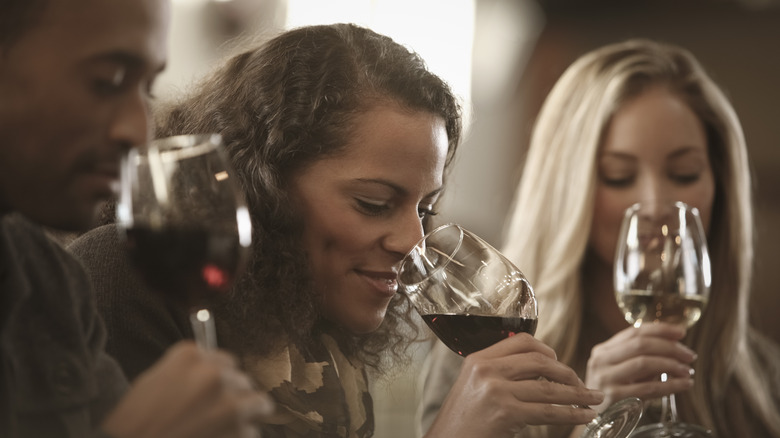 Three people tasting wine together