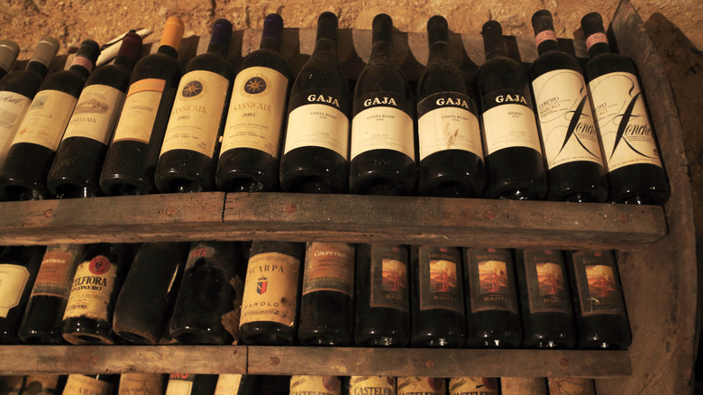 Rows of wine bottles on wine rack in cellar