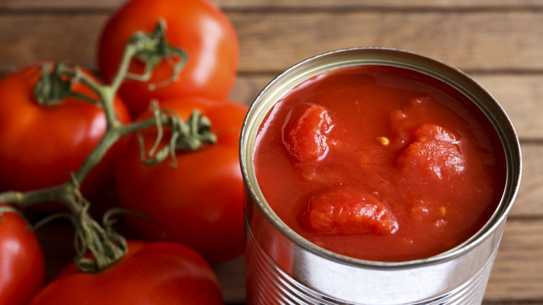 Canned tomatoes next to fresh tomatoes 