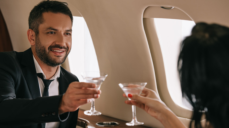 people toasting with martini on plane