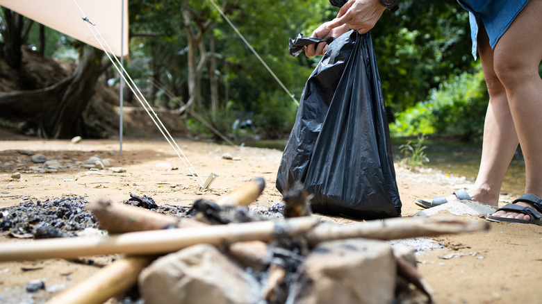 woman closing trash bag camping